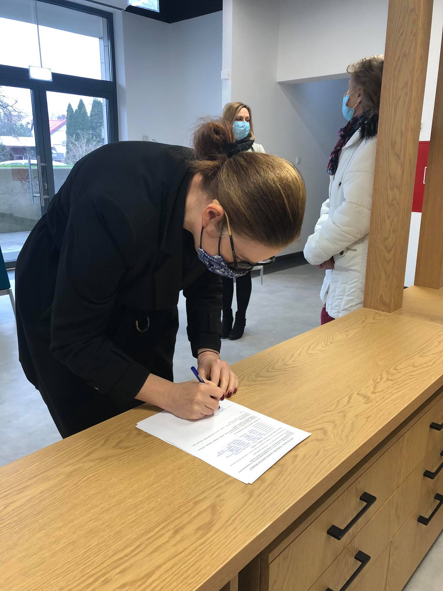 kobieta podpisująca dokumenty